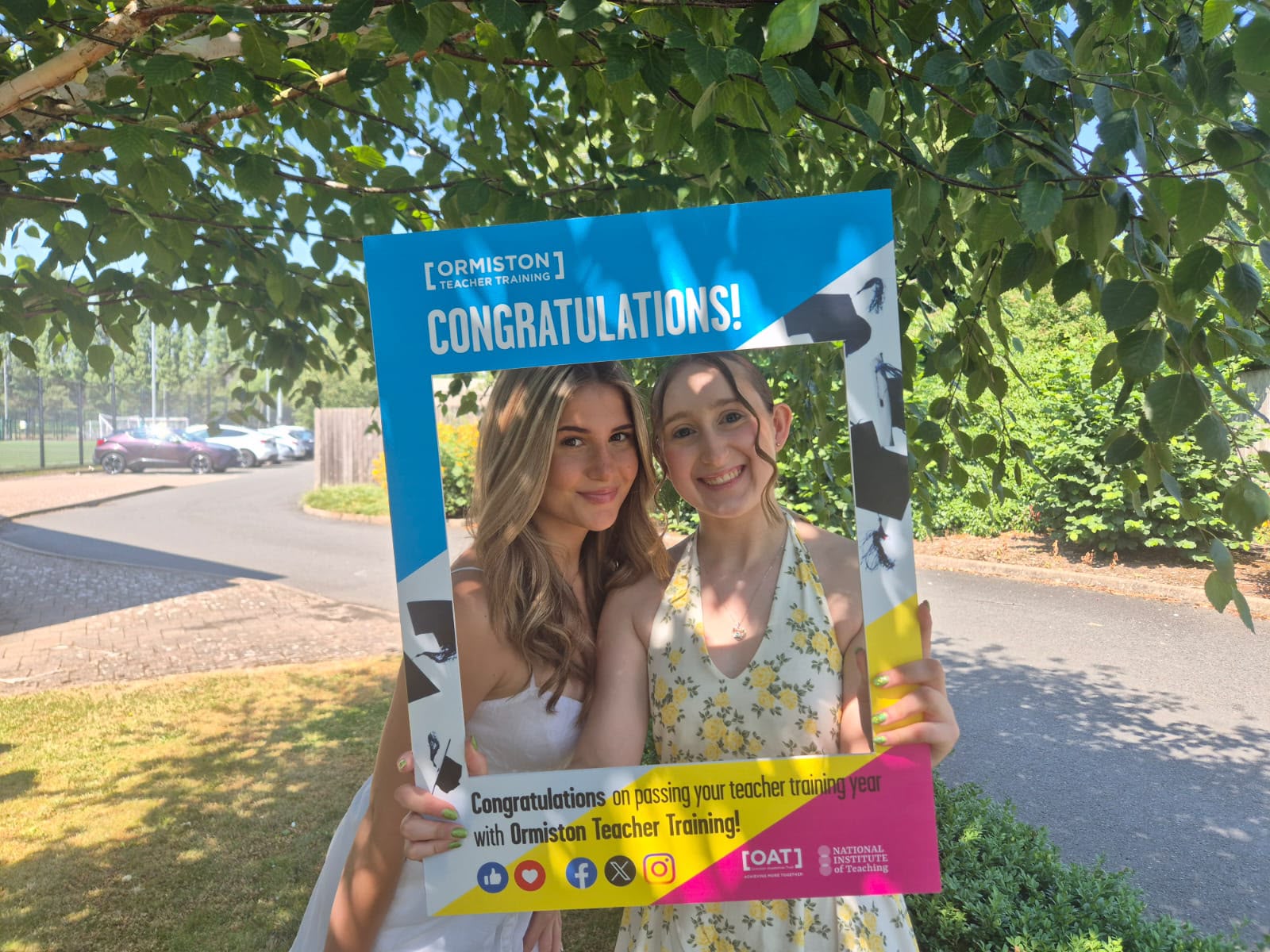 Two trainees celebrating passing their teacher training year